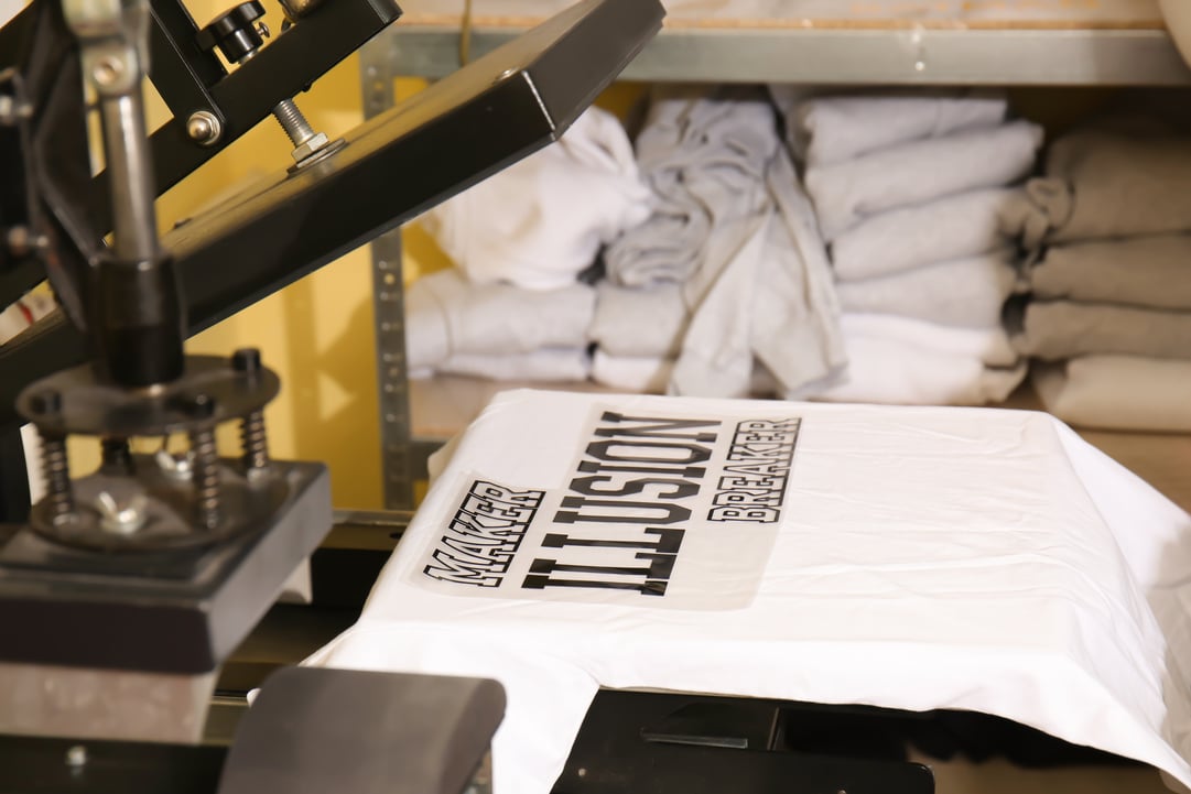 Young Man Printing on T-Shirt at Workshop